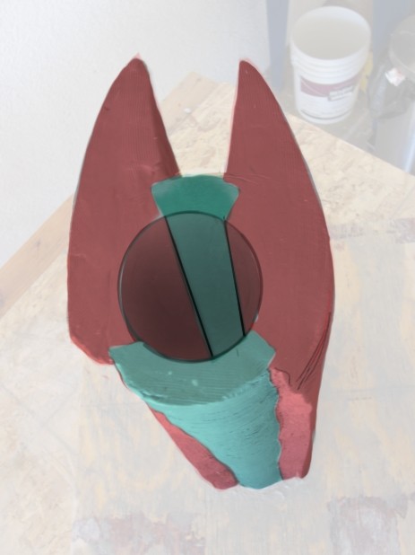 Painted clay maquette seen from above, red shell and teal core
